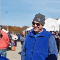 Man in sunglasses and beanie hat smiling as he talks to a woman